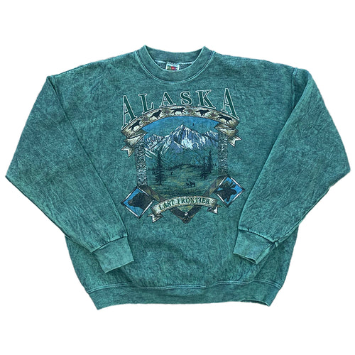 green dyed pullover with ALASKA written on the front with a mountain scenery and last frontier on a banner. 