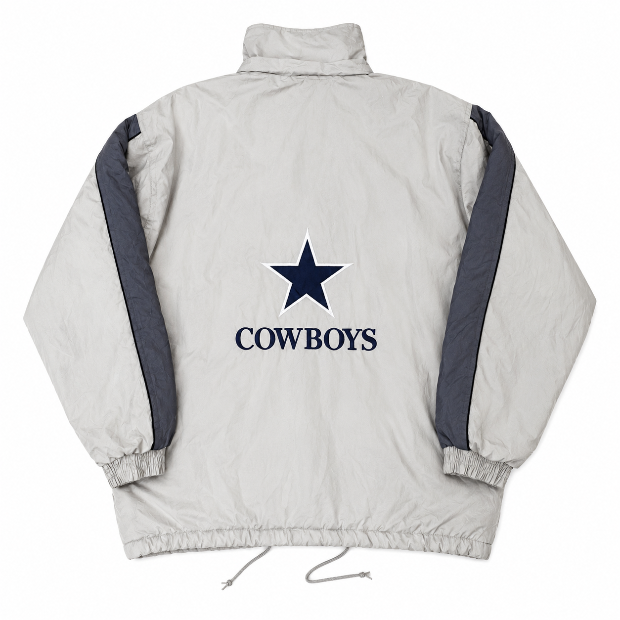 A light tan puffer jacket shown from the back, featuring a navy blue Dallas Cowboys star logo and the word 'COWBOYS' printed in the center, with dark gray sleeve stripes.