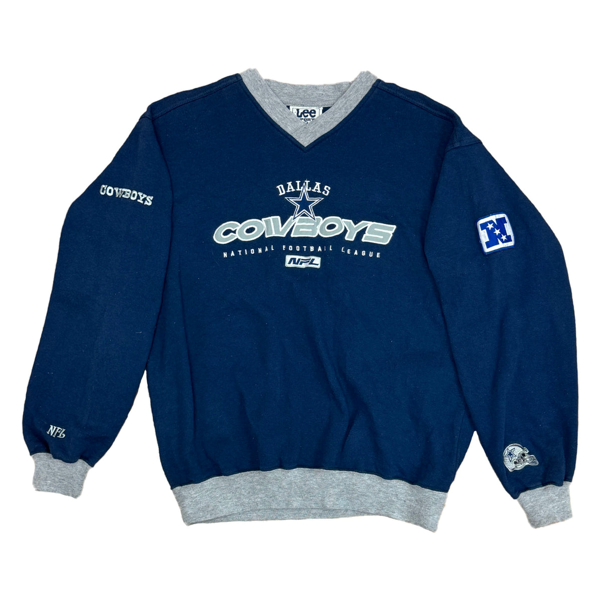 V-NECK SWEATSHIRT THAT HAS GRAY ON THE RIBBING AND NAVY FOR THE BODY. HAS DALLAS COWBOYS LOGO ON THE FRONT AND COWBOYS ON RIGHT SLEEVE AND THE LOGO N AND COWBOY HELMET ON THE LEFT LONG SLEEVE.