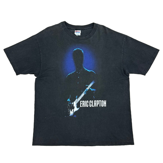 Eric Clapton in white lettering with a black silhouette of eric clapton and a blue haze behind him on a black shirt